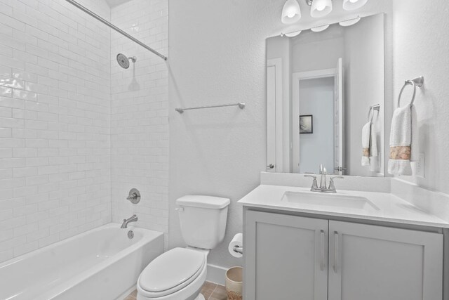 bathroom with baseboards, vanity, tub / shower combination, and toilet