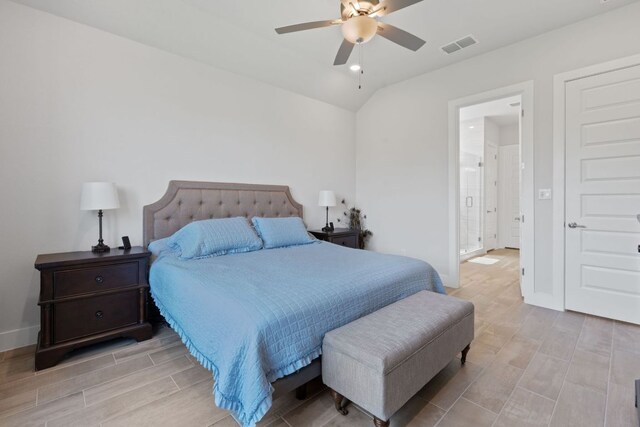 bedroom featuring vaulted ceiling, visible vents, baseboards, light wood-style flooring, and ensuite bathroom
