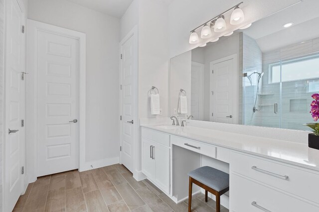 bathroom featuring recessed lighting, a shower stall, baseboards, and vanity