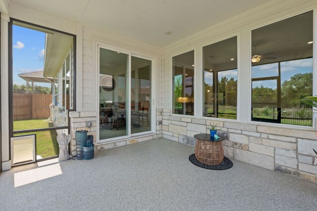 unfurnished sunroom with a ceiling fan