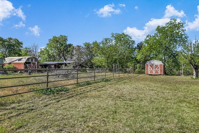 view of yard with a storage shed, an outbuilding, and fence