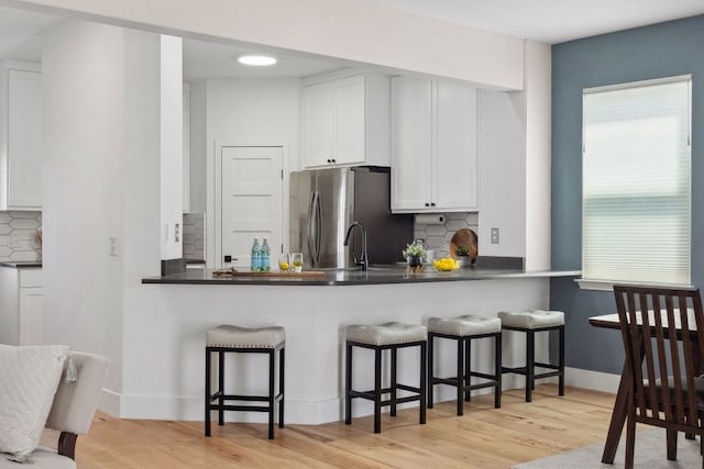 7617 Carver Ave Unit 1, Austin, TX 78752 - kitchen with freestanding refrigerator, light wood-style flooring, and decorative backsplash