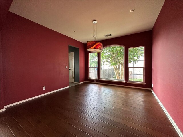 spare room featuring dark wood finished floors, baseboards, and visible vents