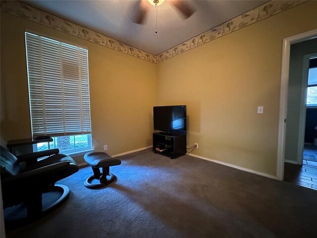 living area featuring carpet flooring, baseboards, a wealth of natural light, and ceiling fan