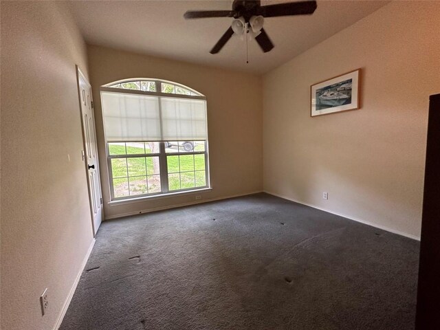 carpeted spare room featuring ceiling fan and baseboards