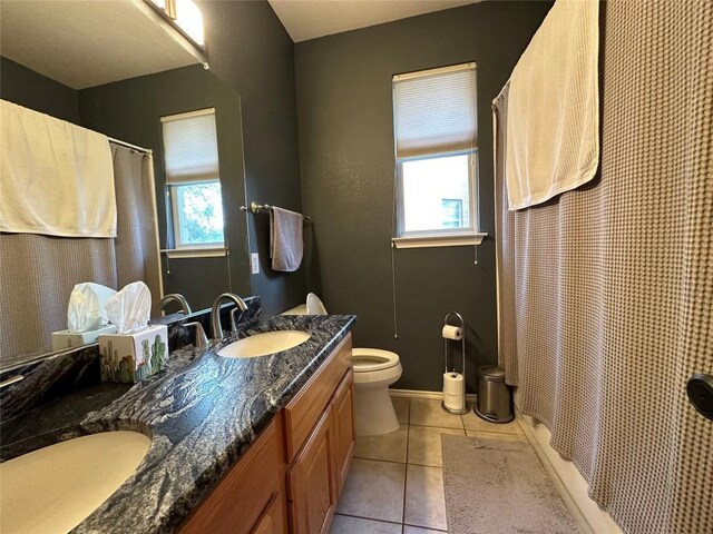 bathroom featuring toilet, tile patterned flooring, a sink, and double vanity