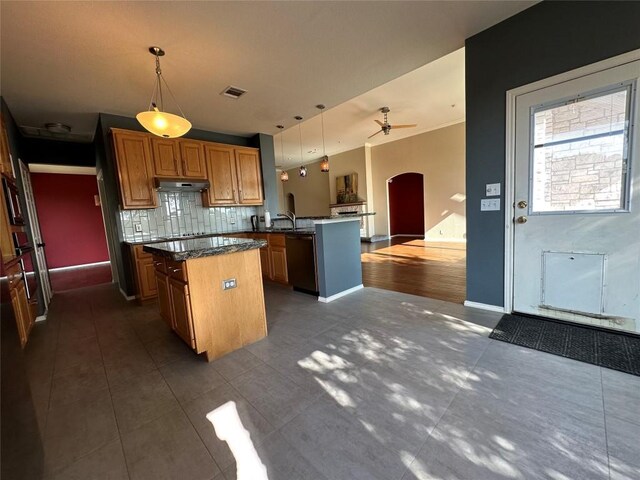 kitchen featuring a center island, open floor plan, arched walkways, a peninsula, and black dishwasher
