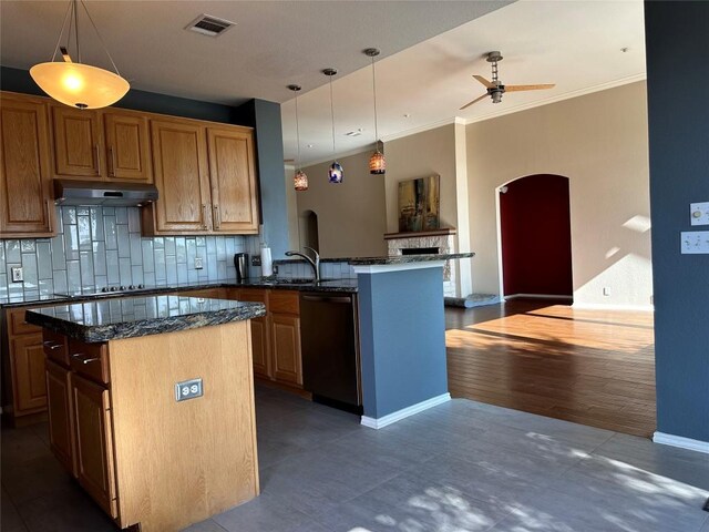 kitchen featuring under cabinet range hood, dishwasher, visible vents, arched walkways, and tasteful backsplash