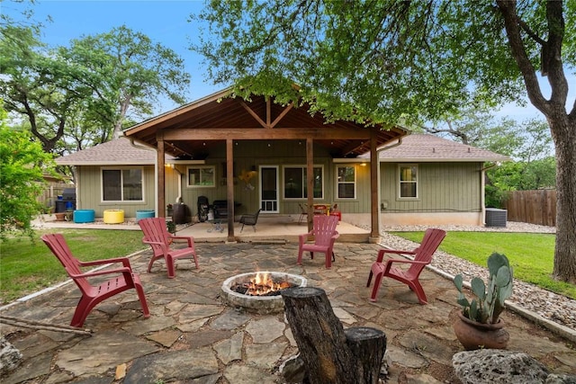 back of property with a yard, a fire pit, fence, central air condition unit, and a patio