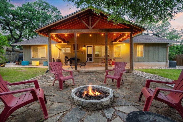 11311 Aloysia Dr, Austin, TX 78748 - back of property at dusk with an outdoor fire pit, a patio area, central air condition unit, and roof with shingles
