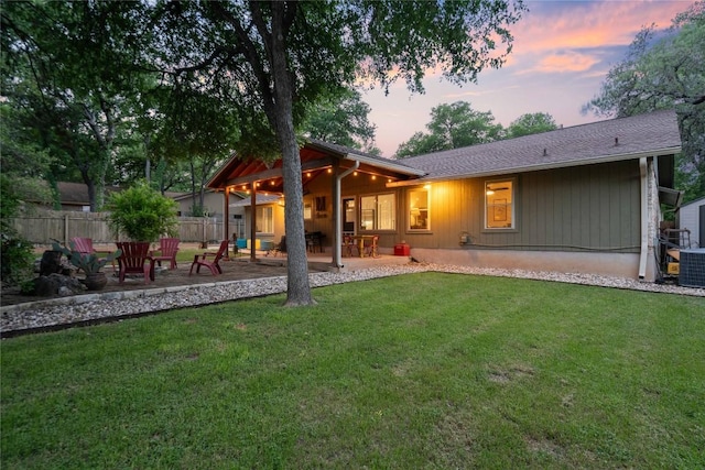 rear view of house featuring a patio area, central AC unit, fence, and a yard