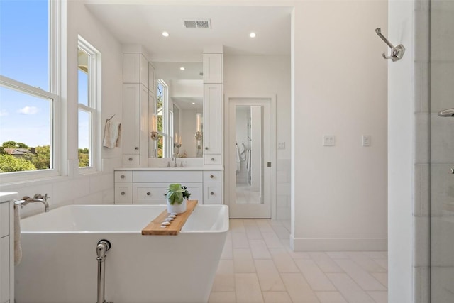 4014 Walnut Clay Dr, Austin, TX 78731 - bathroom featuring a soaking tub, vanity, recessed lighting, and tile patterned floors