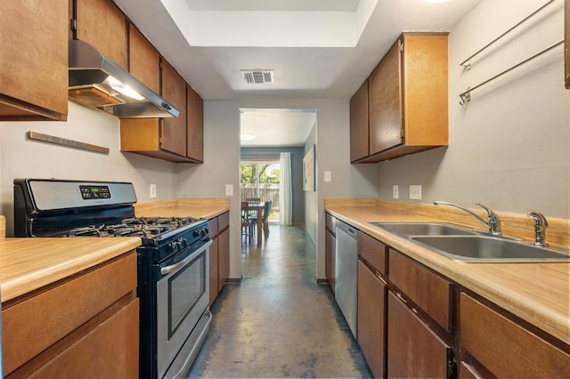 kitchen featuring concrete floors, a sink, appliances with stainless steel finishes, under cabinet range hood, and visible vents