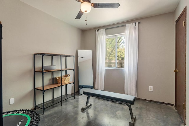 workout area featuring a ceiling fan and baseboards