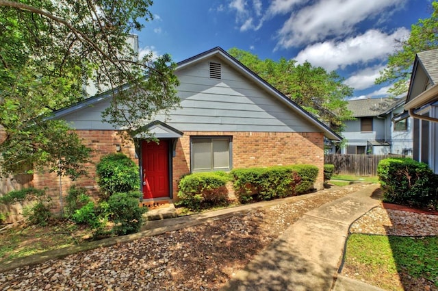 bungalow featuring fence and brick siding