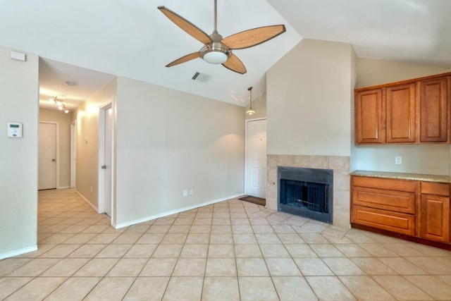 unfurnished living room with vaulted ceiling, light tile patterned floors, ceiling fan, a fireplace, and visible vents