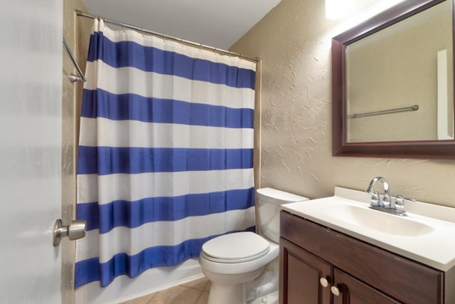 bathroom with tile patterned floors, a shower with curtain, toilet, a textured wall, and vanity