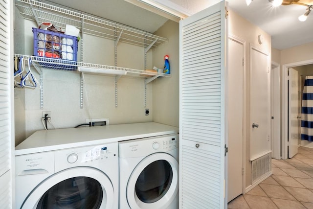 laundry room featuring visible vents, washer and clothes dryer, laundry area, and light tile patterned floors
