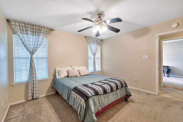 bedroom with ceiling fan, baseboards, and carpet flooring