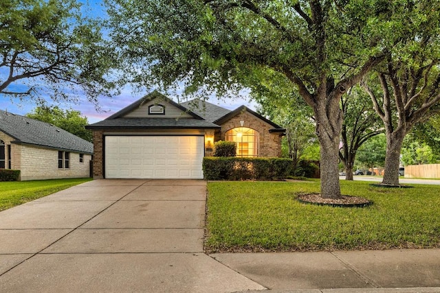 single story home with an attached garage, a front lawn, driveway, and brick siding