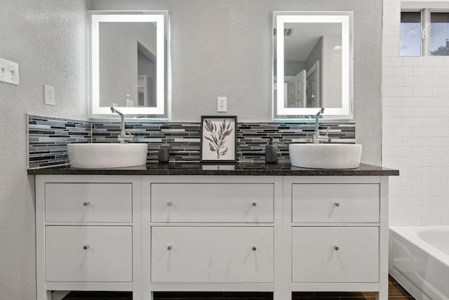 bathroom featuring tasteful backsplash, a sink, and double vanity