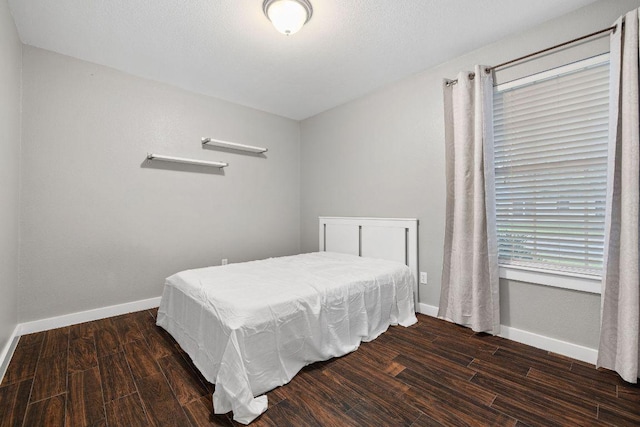 bedroom featuring wood finished floors and baseboards