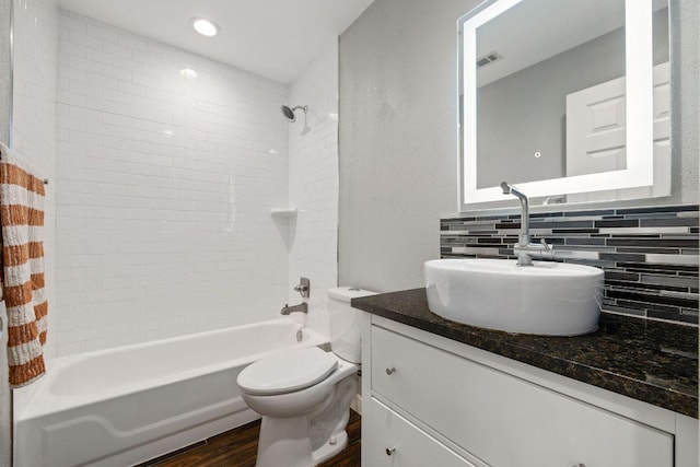 full bathroom featuring visible vents, decorative backsplash, wood finished floors, vanity, and tub / shower combination