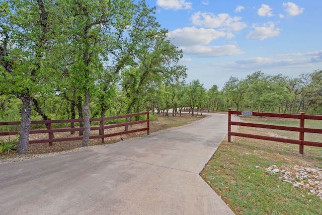 view of community featuring fence and driveway