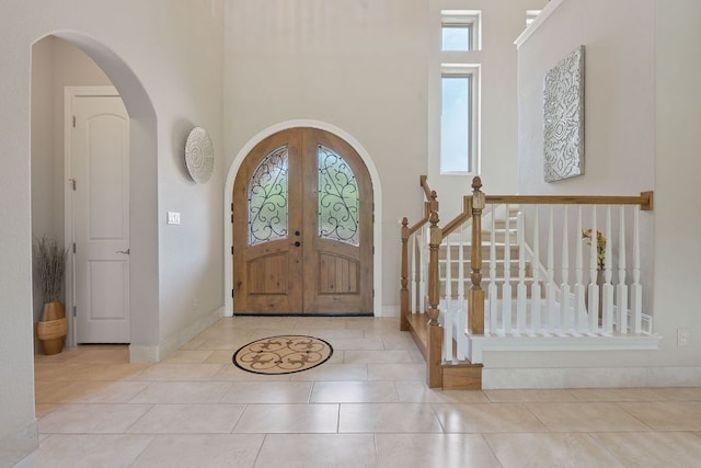 16016 Palomino Ranch Dr, Leander, TX 78641 - entrance foyer featuring a high ceiling, arched walkways, tile patterned flooring, and french doors