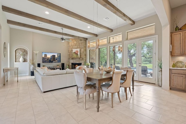 dining area featuring a stone fireplace, light tile patterned flooring, ceiling fan, beamed ceiling, and visible vents