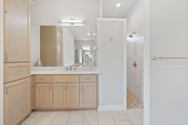 bathroom featuring marble finish floor, recessed lighting, vanity, and a walk in shower