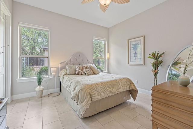bedroom with ceiling fan, baseboards, and light tile patterned floors