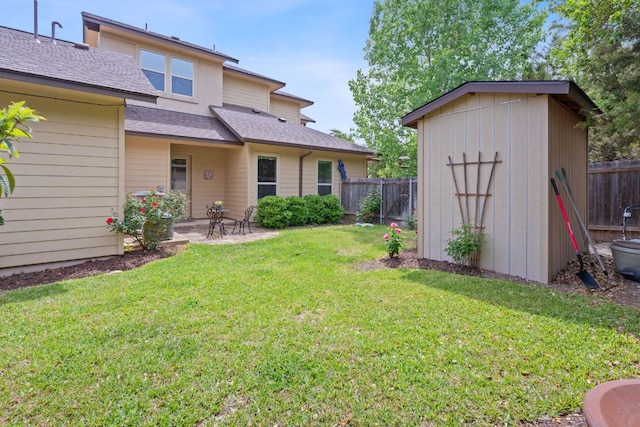 view of yard with a patio, a fenced backyard, an outdoor structure, and a shed