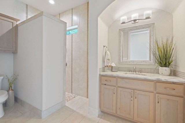 full bathroom featuring tile patterned floors, toilet, vanity, baseboards, and walk in shower