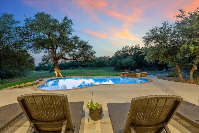 16016 Palomino Ranch Dr, Leander, TX 78641 - pool at dusk with a patio area, an in-ground hot tub, and an outdoor pool