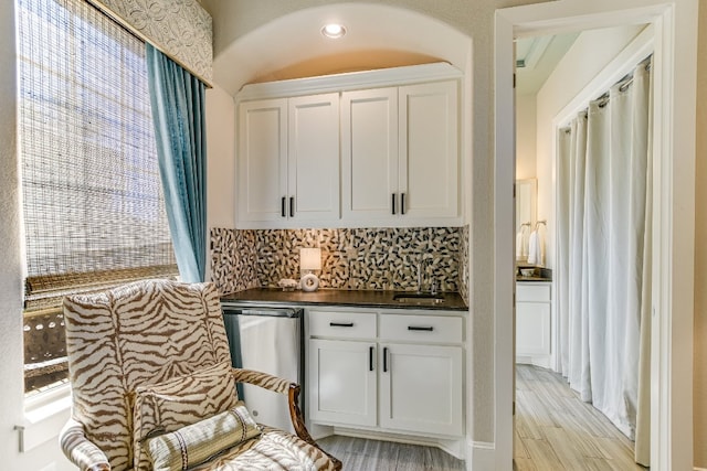 100 Red Rose Dr, Georgetown, TX 78628 - kitchen with dark countertops, backsplash, white cabinetry, light wood finished floors, and plenty of natural light