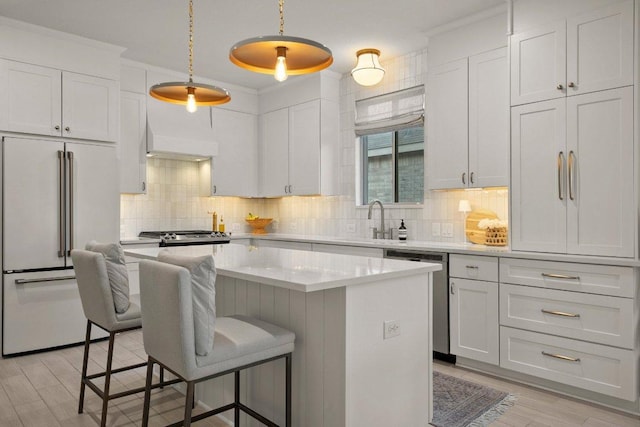 370 Grace Lilly Dr, Buda, TX 78610 - kitchen featuring high end white refrigerator, stainless steel dishwasher, light wood finished floors, a kitchen bar, and a center island