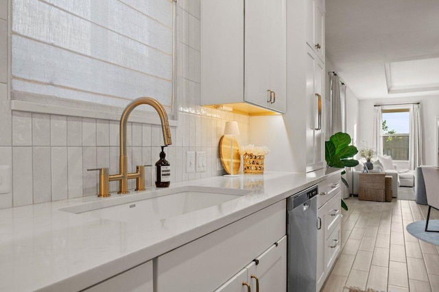 370 Grace Lilly Dr, Buda, TX 78610 - kitchen with a sink, stainless steel dishwasher, tasteful backsplash, and white cabinetry