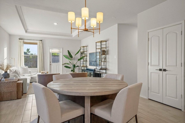 370 Grace Lilly Dr, Buda, TX 78610 - dining space featuring light wood-style floors, a raised ceiling, a chandelier, and recessed lighting