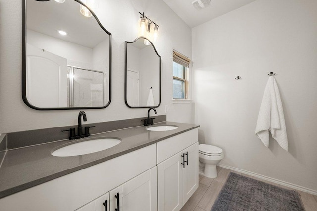 370 Grace Lilly Dr, Buda, TX 78610 - bathroom with double vanity, toilet, a shower with door, and baseboards