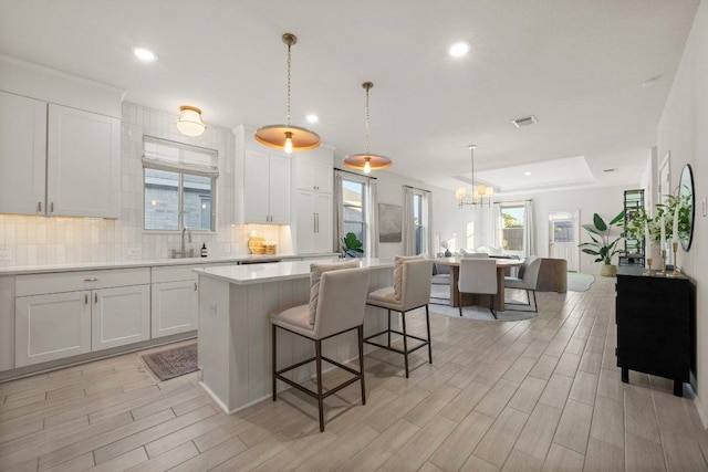 370 Grace Lilly Dr, Buda, TX 78610 - kitchen with decorative backsplash, light countertops, a chandelier, white cabinetry, and recessed lighting