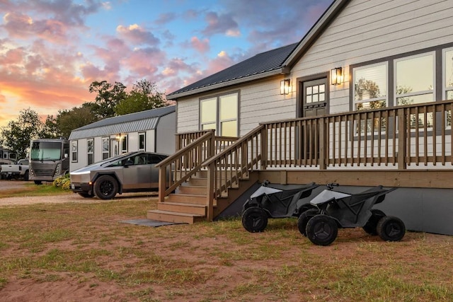 back of property at dusk featuring a yard and metal roof