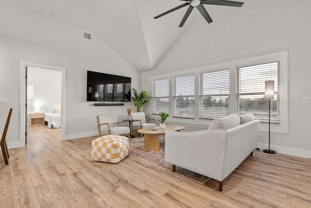 living room with high vaulted ceiling, a ceiling fan, light wood-style flooring, baseboards, and visible vents