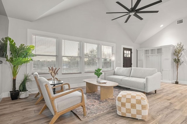 living room featuring light wood-style floors, visible vents, baseboards, and ceiling fan