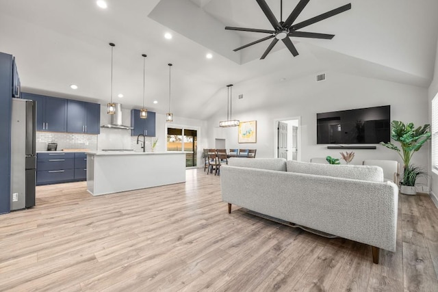 living room with visible vents, recessed lighting, light wood-style floors, a ceiling fan, and a high ceiling