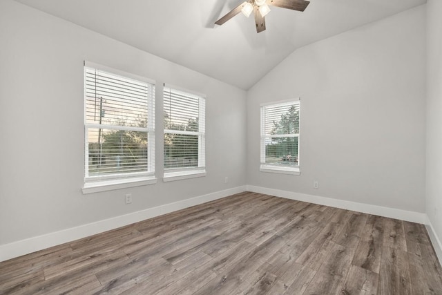 spare room featuring lofted ceiling, a ceiling fan, baseboards, and wood finished floors