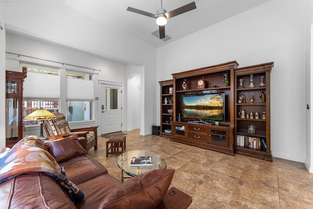living room featuring arched walkways, visible vents, baseboards, and ceiling fan