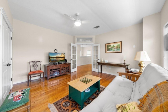 living room featuring a ceiling fan, wood finished floors, french doors, baseboards, and visible vents