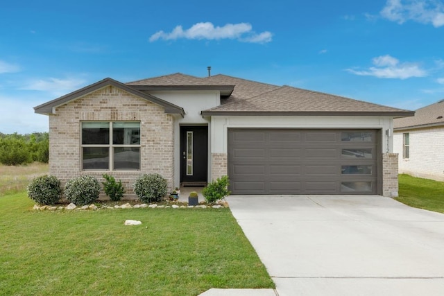 view of front of home with brick siding, an attached garage, a front yard, and driveway