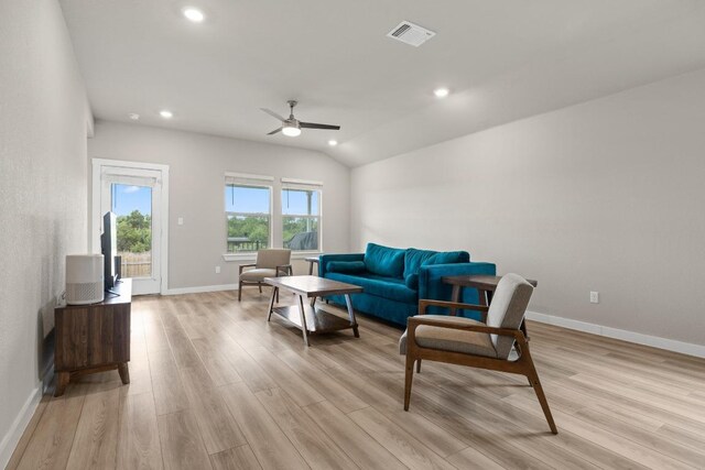 living room featuring light wood-style floors, ceiling fan, baseboards, lofted ceiling, and visible vents